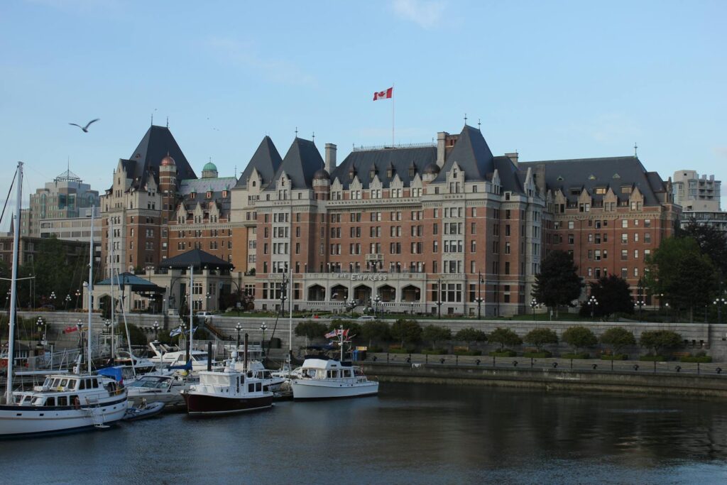 Scenic view of Fairmont Empress Hotel with yachts moored at Victoria Harbor, BC, Canada.